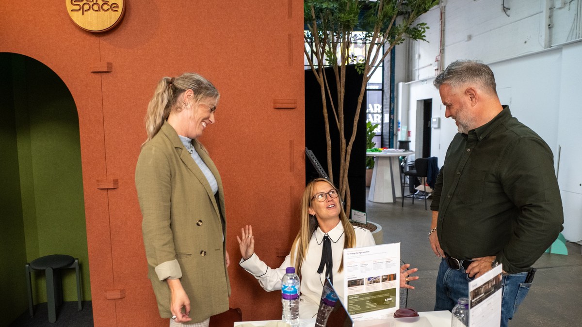 The Simple Acoustics team talking with visitors at the Simple Safe Space stand, Neuroplaces – The Inclusive Design Show